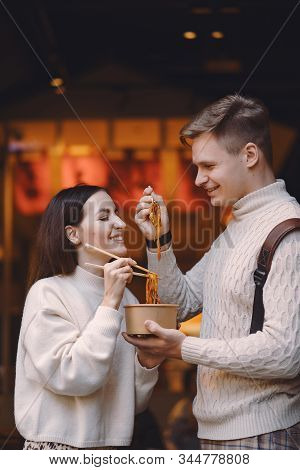 Newlywed Couple Eating Noodles With Chopsticks In Shanghai Outside A Food Market