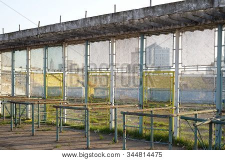 Old Metallic Fence Near A Abandoned Stadium