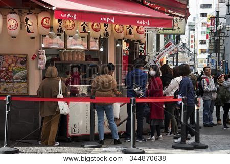 Osaka, Japan- 03 Dec, 2019: Customers Queueing In Front Of Takoyaki Octopus Balls Stall At Dotonburi