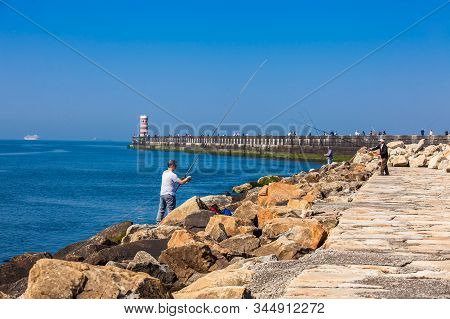 Porto, Portugal - May, 2018: Men Fishing At The Beautiful Porto Coast Near The Douro River Mouth In