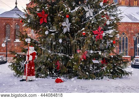 Santa Claus Walking By The Huge Christmas Tree In Riga, Latvia.