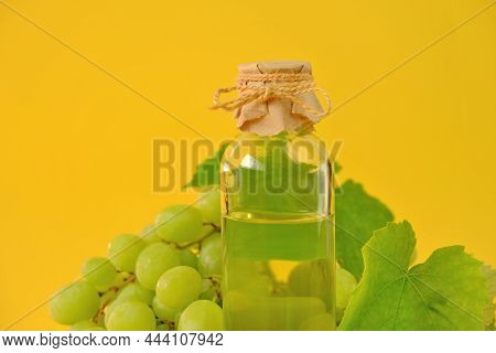 Grape Seed Cosmetic Oil For Massage And Care For Face And Body. Bottle And Bunch Of Green Grapes On 