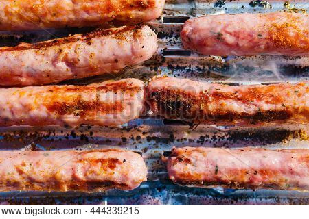 Close Up Delicious Sausages Or Bratwurst On Barbecue Gas Grill. Barbeque Meat Dinner Outdoor.