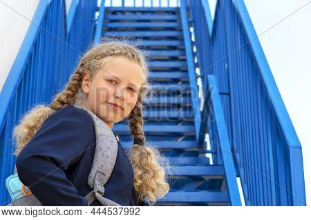 Schoolgirl With A Smile Climbs The Stairs. Concept  School Days, Start Date, Next Stage, Career Ladd
