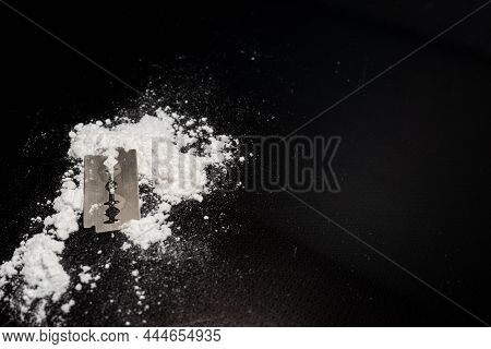 Razor Blade On Drug Powder On Reflection Black Background.copy Space.