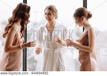Morning Of Bride. Gorgeous Bride With Best Bridesmaids Are Holding Glasses And Drinking Champagne In