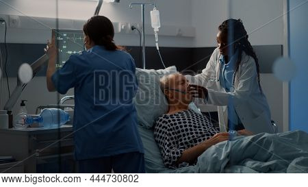 Patient With Breathing Problems In Hospital Ward Bed Needing Reanimation Help From Nurse And African