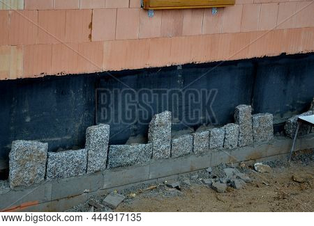 Bricklayers Tiling The House With Sandstone Stones. They Connect Stones With Cement. Behind The Clad