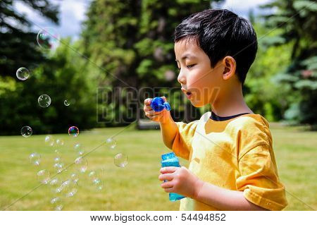 Cute Boy Blowing Soap Bubbles