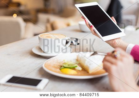 Woman using tablet computer in cafe