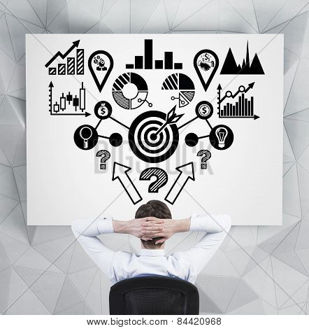 Businessman Looking At  Analitics Scheme