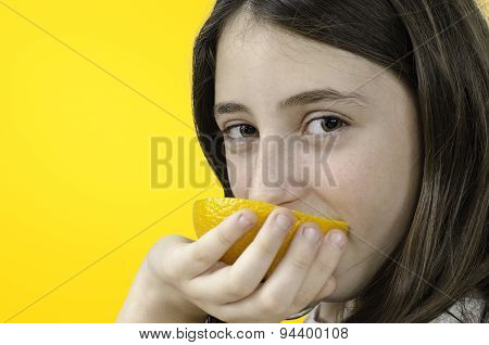 Girl Eating Orange Over Orange Background.
