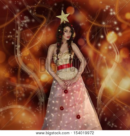 Beautiful young woman dressed like christmas tree with star on head. Studio shot on golden light background. Copy space. Sqaure composition.