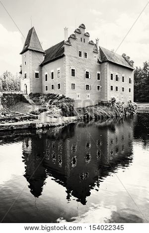 Cervena Lhota is a beautiful chateau in Czech republic. It stands at the middle of a lake on a rocky island. Travel destination. Black and white photo. Beautiful place. Mirrored architecture.