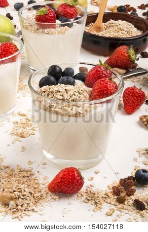 healthy breakfast with fresh cold yoghurt strawberries blueberries and oatflakes in a glass