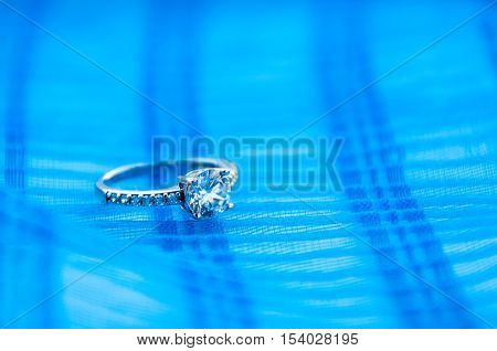 Silver ring with cubic zirconia on a blue background