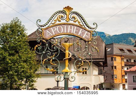 Beautiful wrought metal ornamental pharmacy street sign in the alpine village St. Gilgen Austria