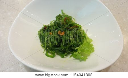 Chuka salad with sesame seeds on the wood background