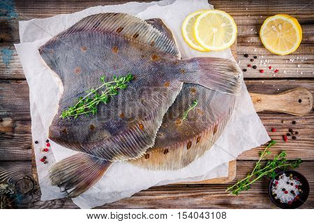 Raw flounder fish flatfish on wooden background