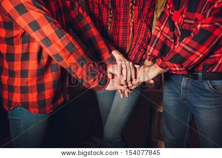 Style lumberjack. The company of young men and a girl dressed in lumberjack style on a wooden background