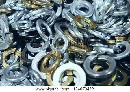 Many shims arranged as background. Metal fasteners, scattered in plastic cells.