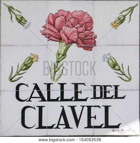 MADRID, SPAIN - MARCH 13, 2016: Closeup of the street sign. Street signs in Madrid are hand-painted ceramic tiles typically composed within 9 or 12 tiles. They depict the name of street and illustrations with special meanings.