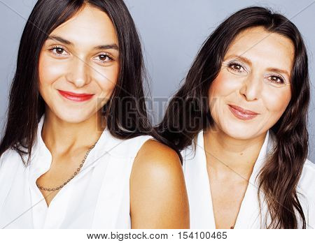 cute pretty teen daughter with mature mother hugging, fashion style brunette makeup close up, real happy family