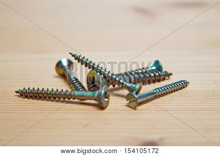 Golden and silver Screws screwed on white background