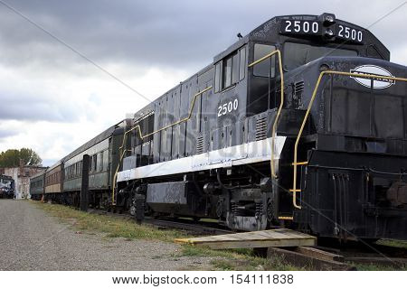 Black old vintage train under gloomy sky