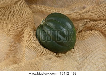 Raw whole uncooked acorn squash on burlap