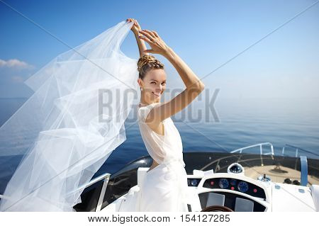 Happy bride posing on a yacht on wedding day