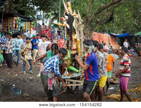 KOLKATA, INDIA - OCTOBER 11, 2016: Men carry Durga idol for immersion in the Ganges river. The idol immersion in the marks the end of the five day durga puja in West Bengal.