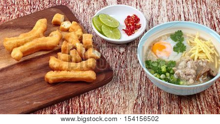 Rice porridge with mined pork and chicken lever served with side dish as Patongko (deep-fried dough stick) and spicy sour filling.