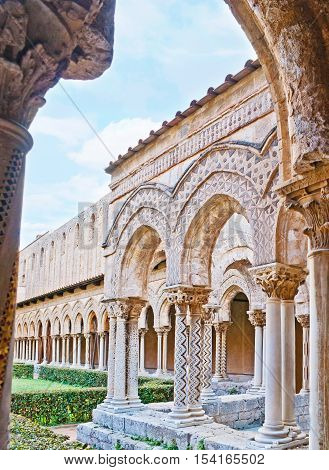 The old garden of Monreale Cloister surrounded by the scenic arcade with unique columns decorated in different technics Sicily Italy.