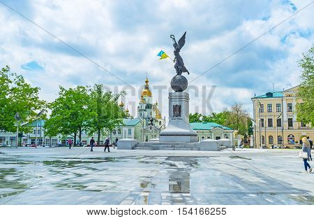 KHARKOV UKRAINE - MAY 20 2016: The Independence Monument named Flying Ukraine with the golden bell towers of the Holy Virgin Monastery on the background on May 20 in Kharkov.