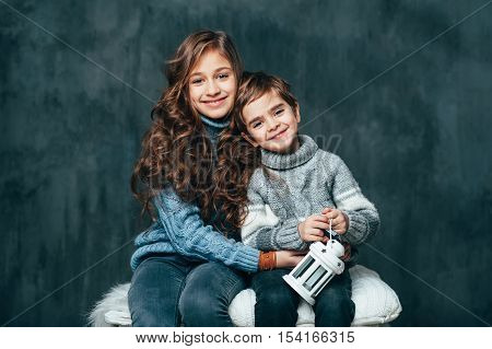 Brother and sister are hugging on the soft white pillow