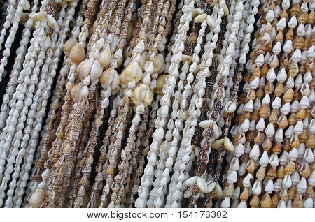 Sea shells, strung on a rope photographed on a street layout merchant souvenirs, as a background, texture, texture, diagonal arrangement.
