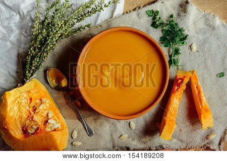 Pumpkin Porridge And Pumpkins On Black Wooden Table. Plate Pumpk