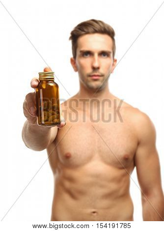 Muscular man holding drugs on white background