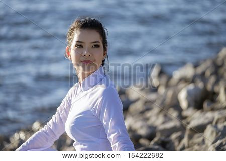 Beautiful woman in Vietnam culture traditional relaxing on lake beside blue water