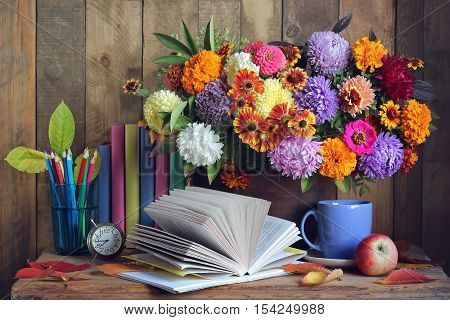 Back to school. September 1 knowledge Day teacher's Day. Still life with books bouquet and alarm clock.