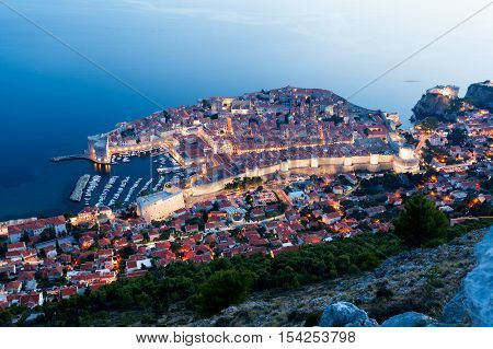 Lovely panoramic view of the old walled city of Dubrovnik with bird's eye view at night. City backlit. Croatia