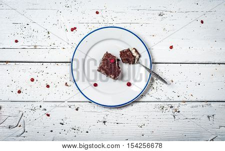 Chocolate cake with cream and fruit on retro wooden table