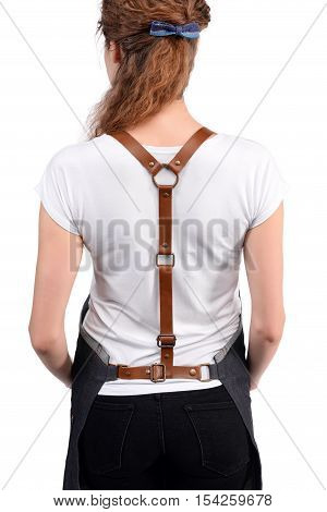 Young redhaired woman chef or waiter posing, wearing apron and white t-shirt isolated on white background