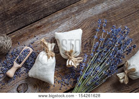 Bunch of lavender flowers and three sachets filled with dried lavender. Top view. Flat lay.