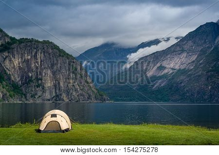 Scenic Norway fjord landscape at late evening with touristic tent close to the shore. Eidfjord, Hordaland, Norway