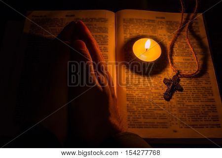man prays on bible selective focus close up