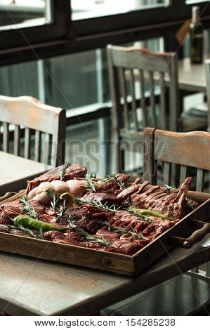 Meat assortment at a spacing in the restaurant decoration with rosemary and pepper.