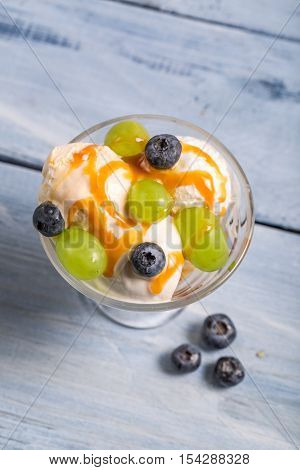 Fruit ice cream with fruits on wooden table