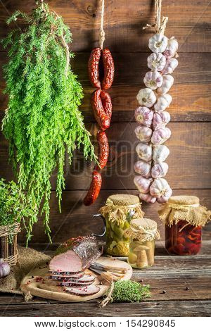 Sliced piece ​​smoked ham with hebrs on old wooden table